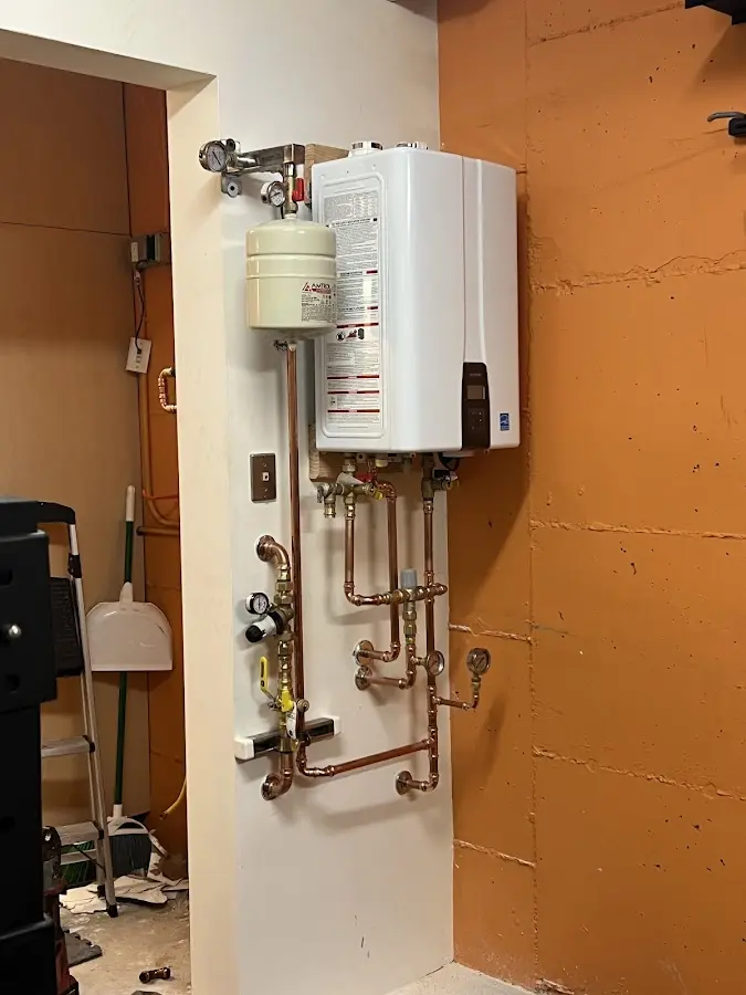 Plumbing technician inspecting water heater connections in Attalla